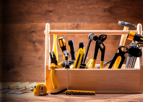 Hand tools including hammers, screwdrivers, wrenches, and pliers organized in a hardware aisle.